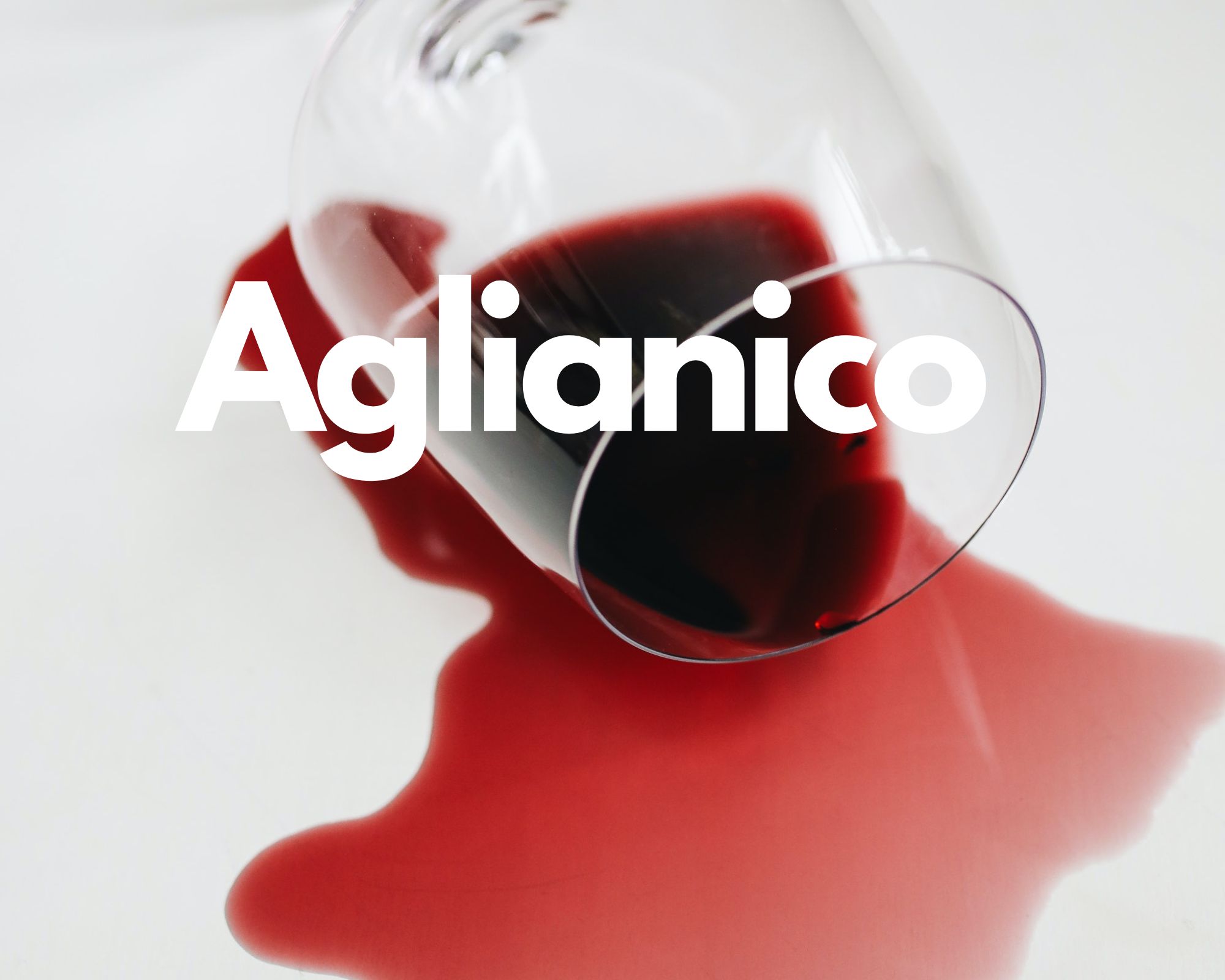 A glass of spilled red wine in a white background, Italian grape varieties