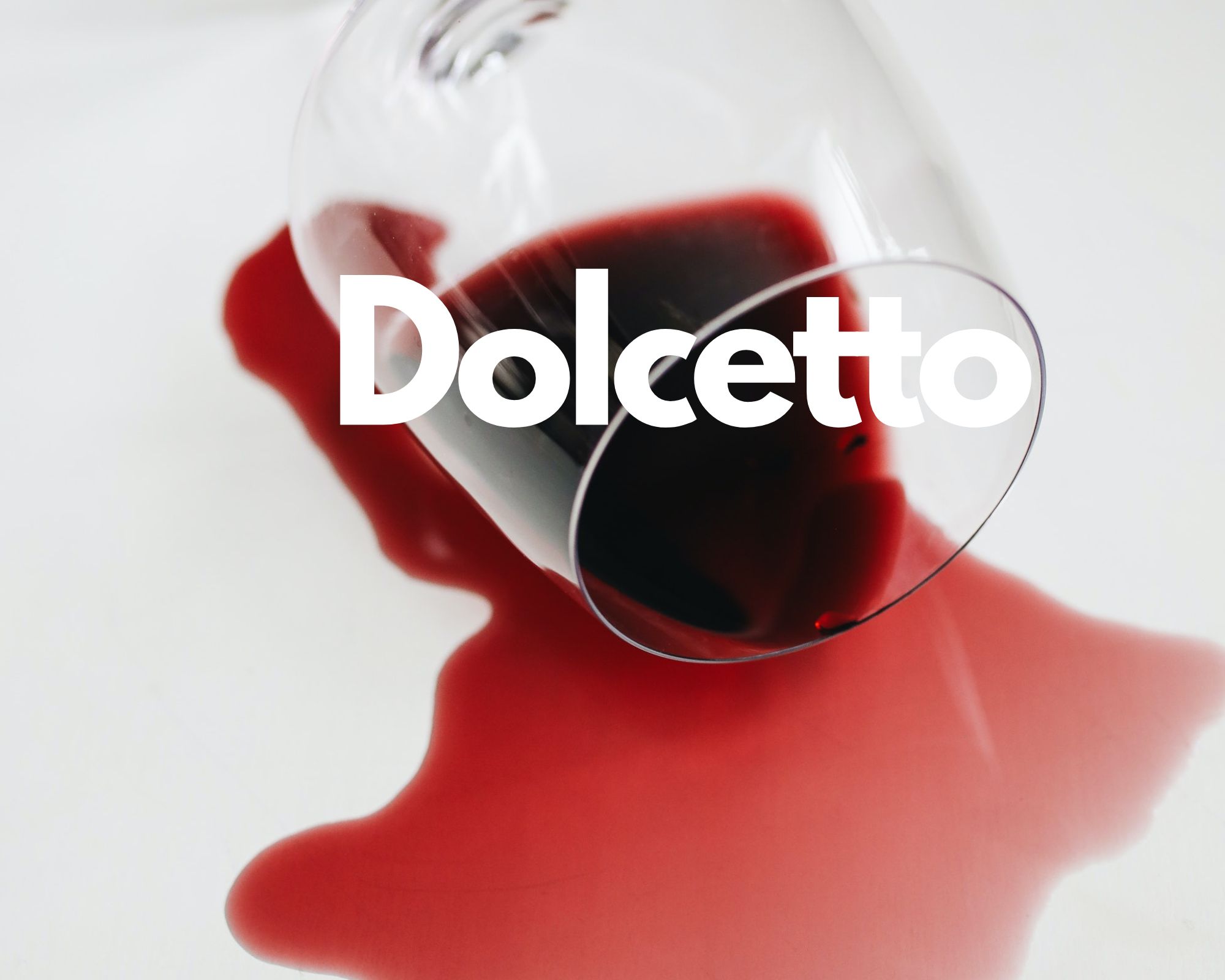 A glass of spilled red wine in a white background, Italian grape varieties