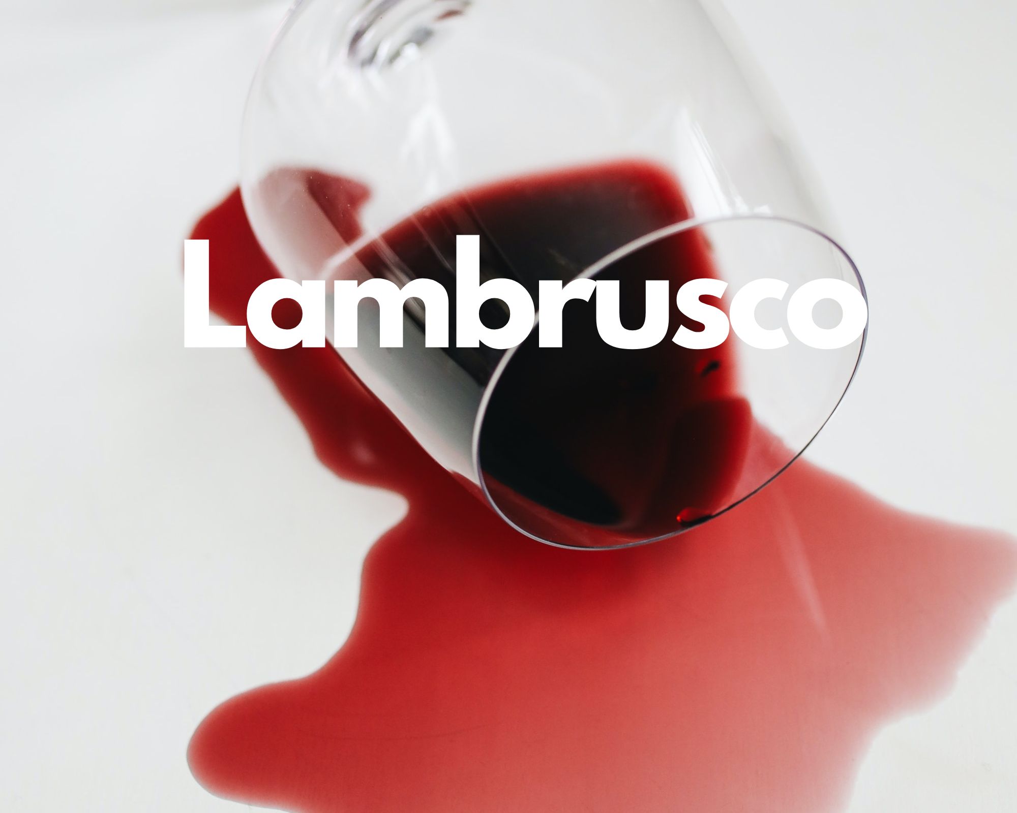A glass of spilled red wine in a white background, Italian grape varieties