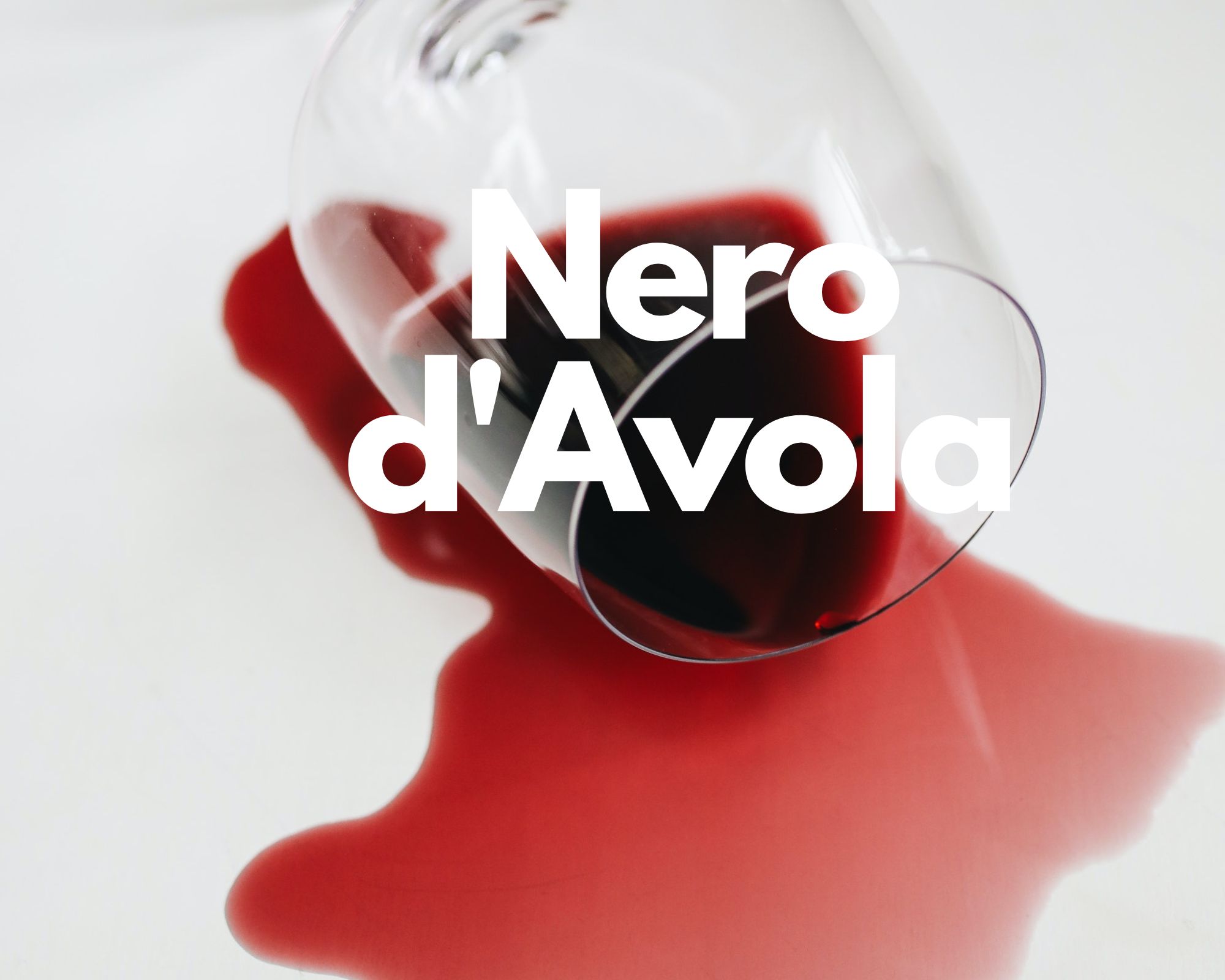 A glass of spilled red wine in a white background, Italian grape varieties