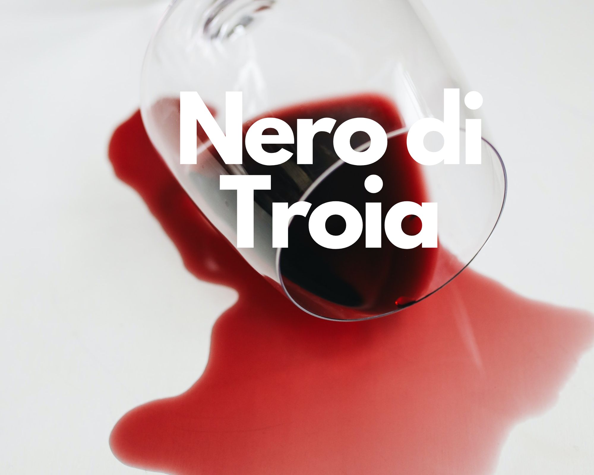 A glass of spilled red wine in a white background, Italian grape varieties