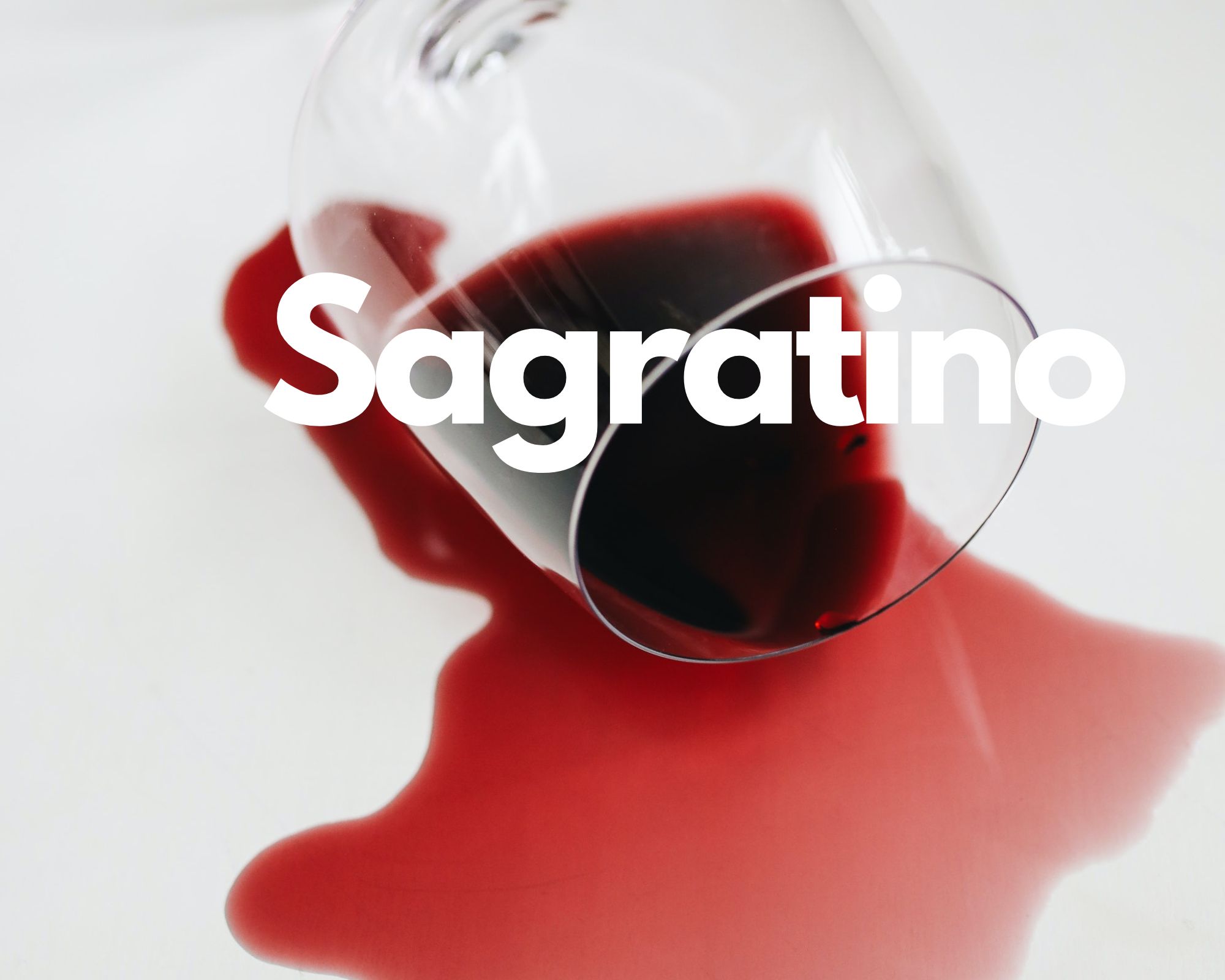 A glass of spilled red wine in a white background, Italian grape varieties