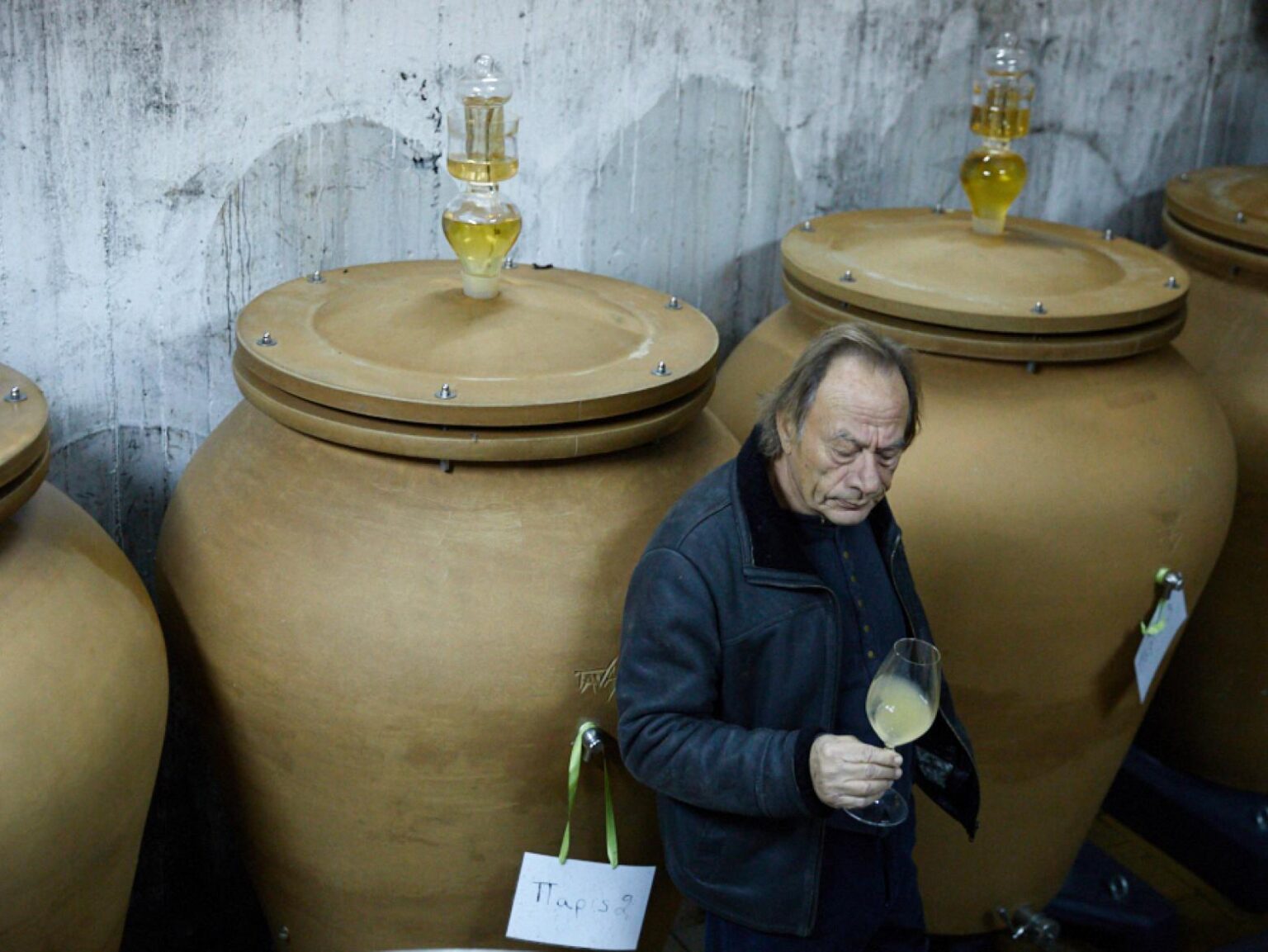 Amphora at Oeno-P winery, Santorini and a man tasting a wine