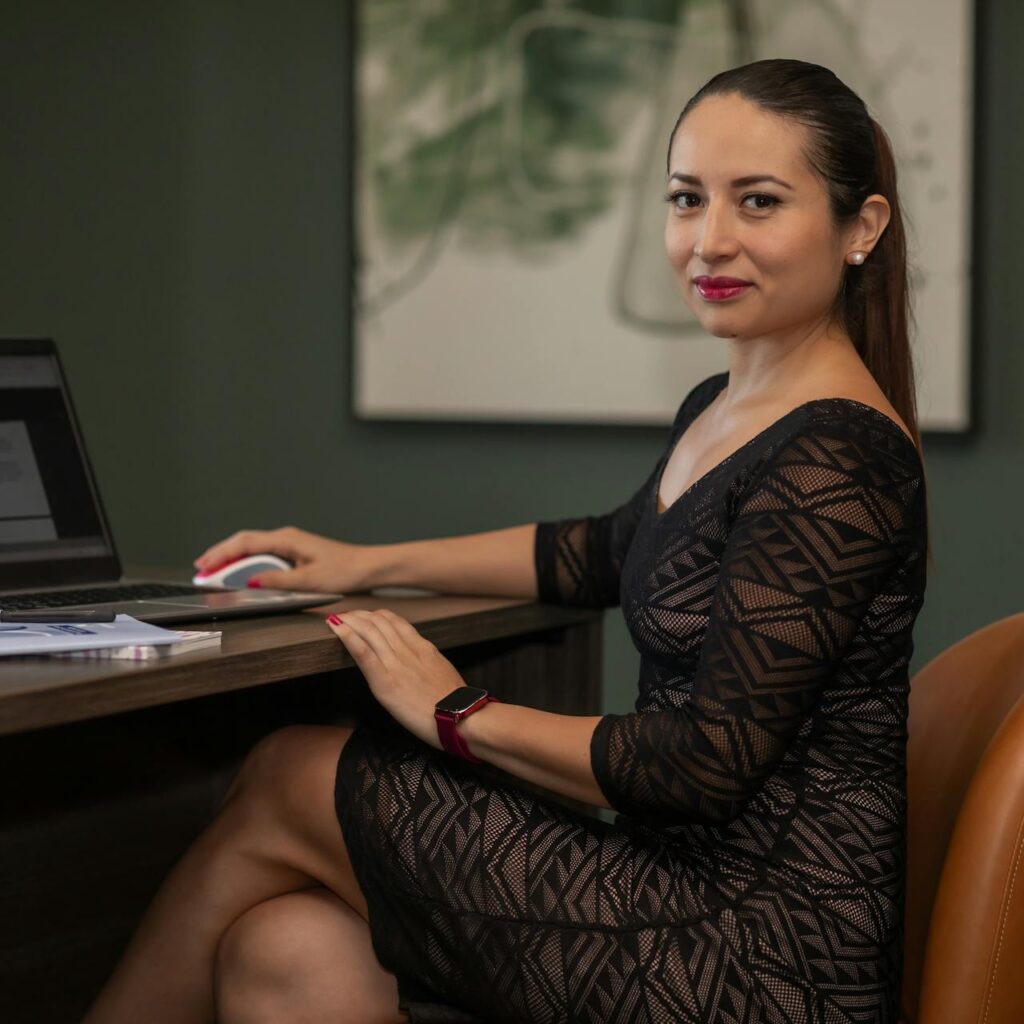 A smiling woman in front of her laptop, is ready to send a request for wine samples from CMK