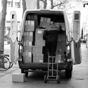 A man works with carton baxes on a truck as he is ready to deliver wine samples from CMK
