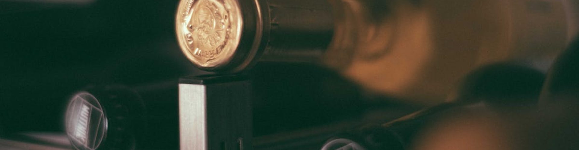 pexels-photo-6088389-6088389 A close-up of a wine bottle with golden seal resting on a metal rack, creating a luxurious ambiance. Use our service to get exclusive wines for importers.